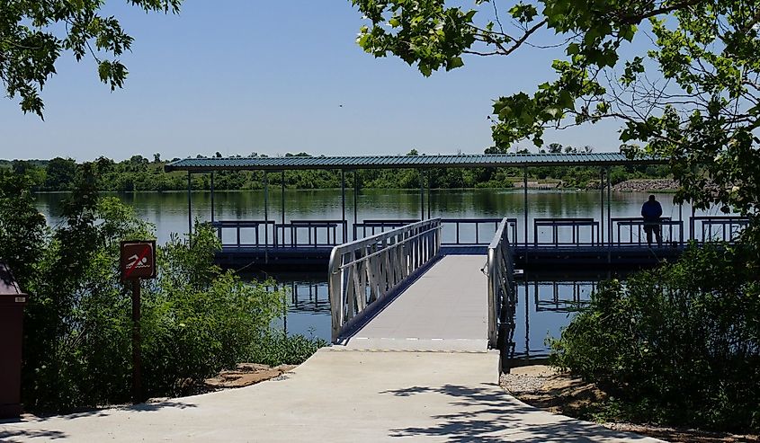 Wide shot of the floating dock with the silhouette of an unrecognizable man at the Veteran Lake, Sulphur, Oklahoma