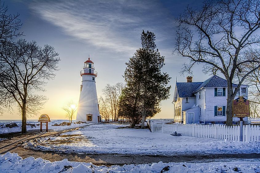 The historic Marblehead Lighthouse in Northwest Ohio sits along the rocky shores of Lake Erie. Seen here at sunrise in winter with snow and ice on the ground.