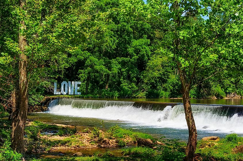 Love sign sits on the opposite New River Bank from Old Mill Resturant, at the end of a waterfall from a weir in Damascus, Virginia.