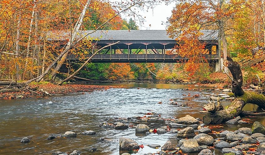 Mohican Covered Bridge spanning over clear fork Mohican river in autumn.