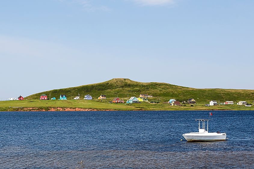 A boat anchors near the shoreline of one of the Magdalen Islands