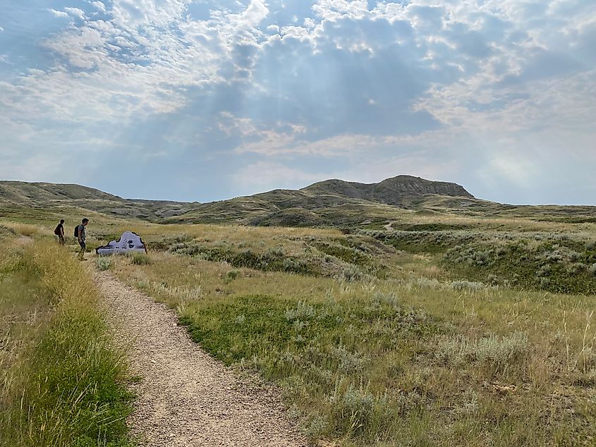 A couple reads the trailhead sign before embarking on a beautiful hike through the prairies.