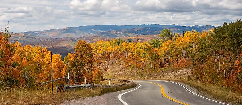 Scenic CO-133 highway passing through McClure pass in Colorado with vibrant fall foliage.