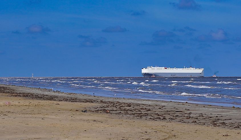 This is a landscape picture of a cargo ship, coming into port in Freeport, Texas
