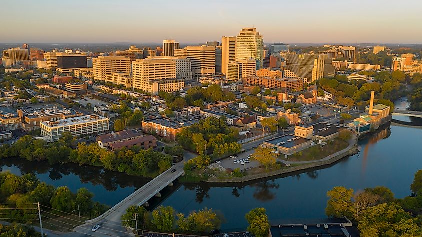 Aerial view of downtown Wilmington, Delaware, at sunset, showing office buildings, residential neighborhoods, and the Christina River winding through the city.