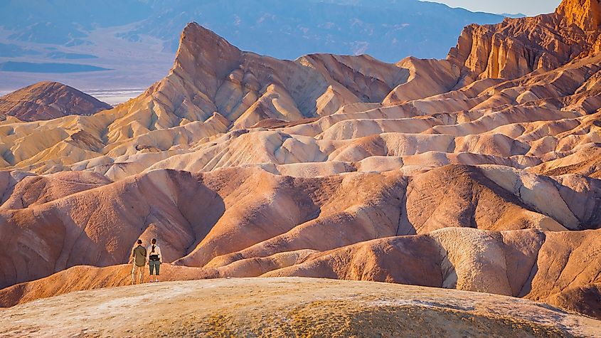 hikers standing in front of beautiful inspiring landscape - death valley national park