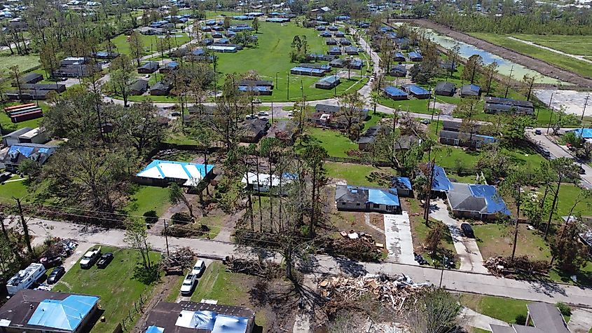 Aerial view of Houma, Louisiana, showing numerous rooftops covered with blue tarps for storm damage protection