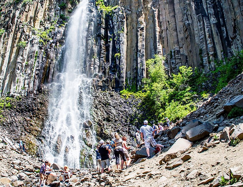 Hikers and tourists watch scenic Palisade Falls. Editorial credit: LI Cook / Shutterstock.com