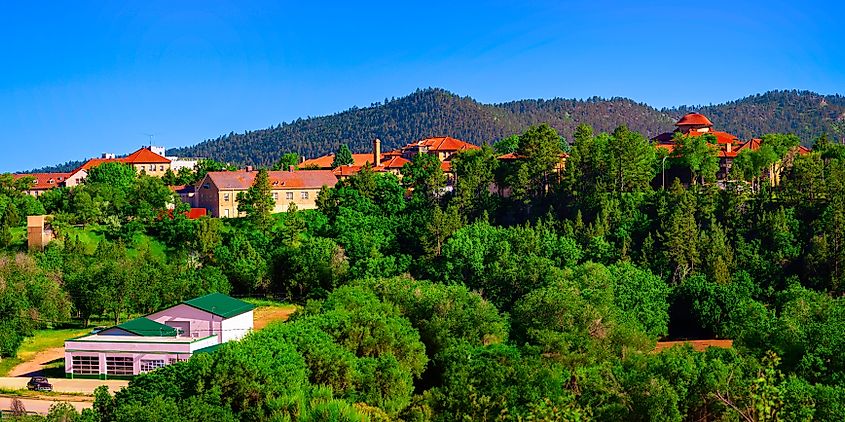 Summer skyline and landscape of South Dakota’s Black Hills, featuring vibrant mountain hills and landmark architecture overlooking Hot Brook Canyon