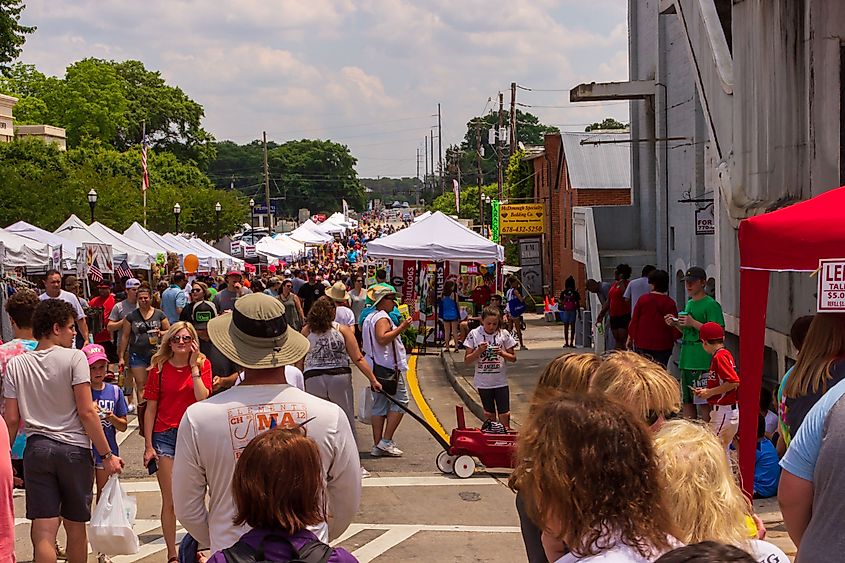 McDonough, Georgia, USA: Crowds stroll between the booths of the 42nd annual Geranium Festival along John Frank Ward Boulevard.