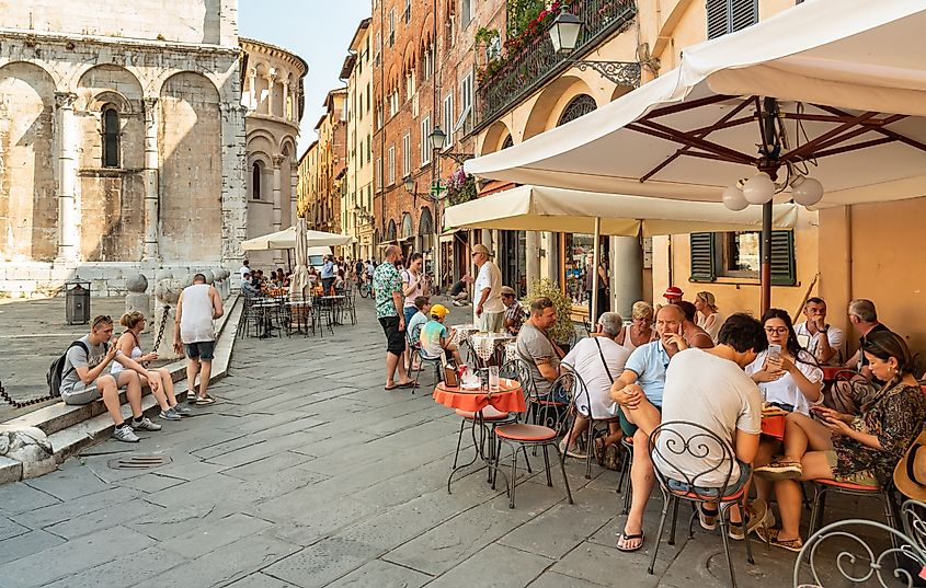 Tourists enjoying historic center of old town Lucca in Tuscany