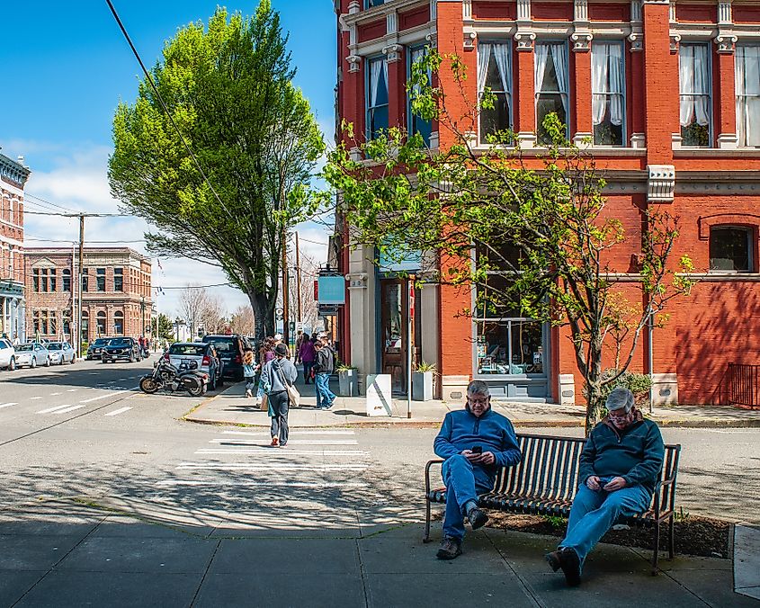 Scene on Water Street in Historic Port Townsend, Washington, USA. Two older men checking social media.