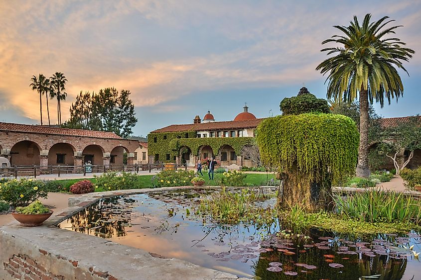 Courtyard of Mission San Juan Capistrano in California at dusk, via Alizada Studios / Shutterstock.com