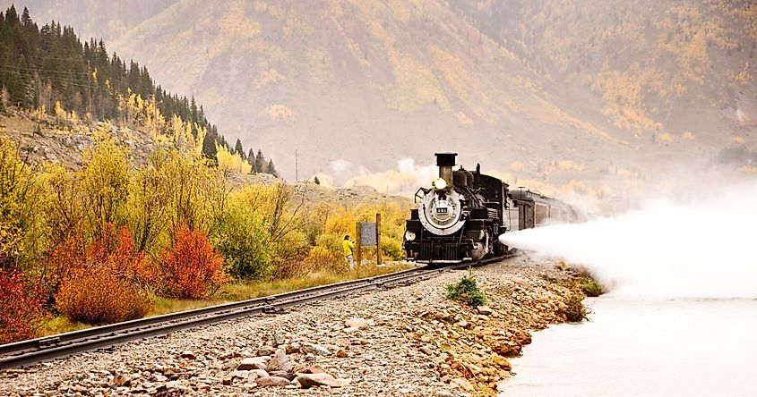 Durango & Silverton Narrow Gauge Railroad crossing fall foliage in the Rocky Mountains.