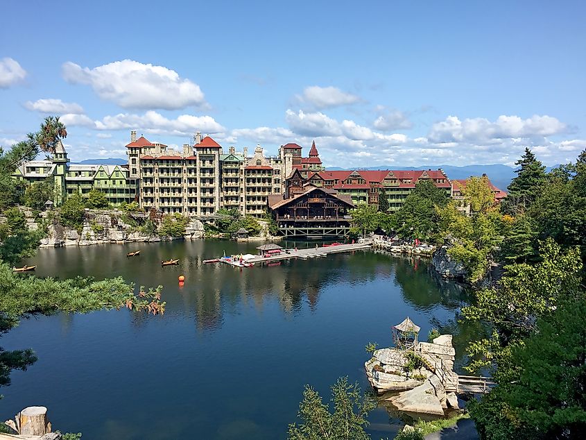 Mohonk Mountain House across a lake with a dock and small rock island in New Paltz, New York.