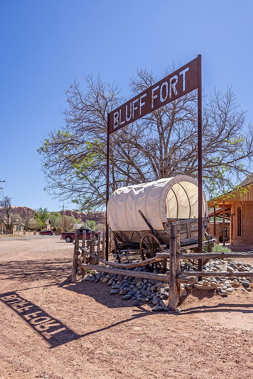 Enclosed wagon on display under the Bluff Fort historic site sign in Bluff, Utah, USA. Editorial credit: Nigel Jarvis / Shutterstock.com