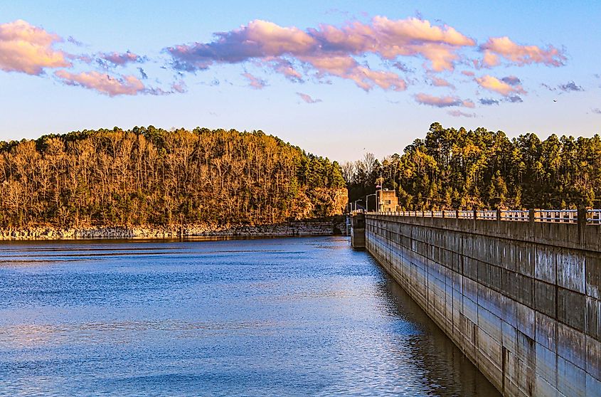 Looking out across the Norfork Dam and Lake as the evening sun is setting in the background shining just over the top.