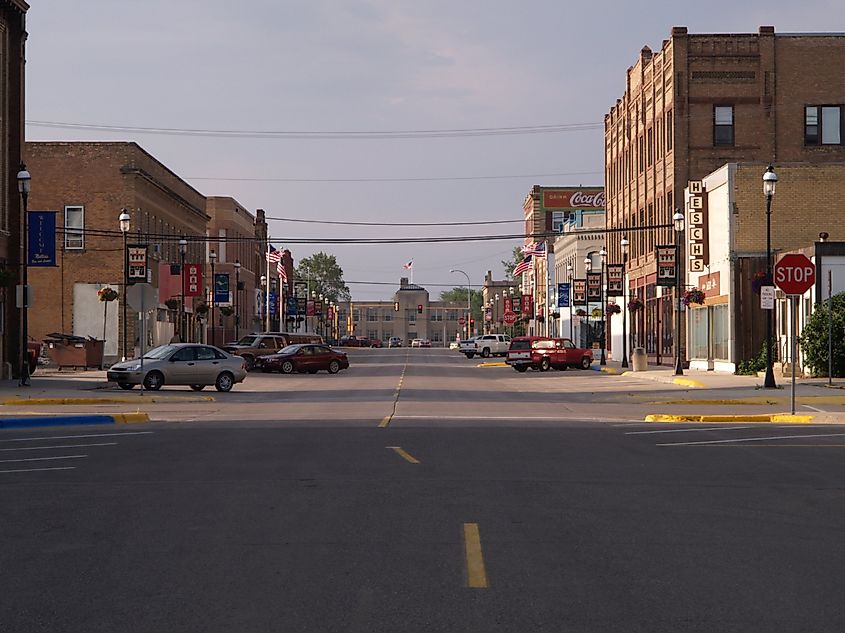 Street view in Devils Lake, North Dakota, featuring local businesses and shops along a wide street.