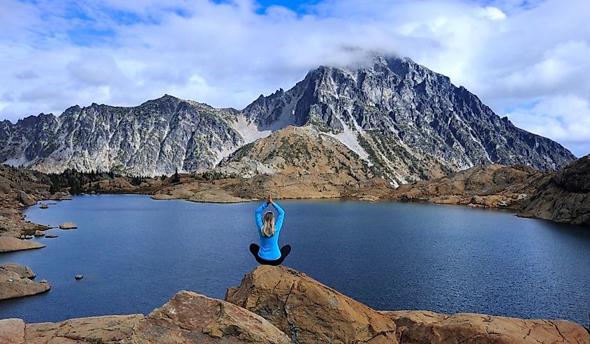 Woman doing yoga pose on a rock over Ingalls Lake.