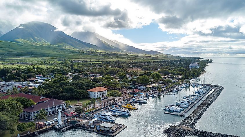 Aerial view of Lahaina, Maui, Hawaii with lush mountains, a boat dock, and a pier