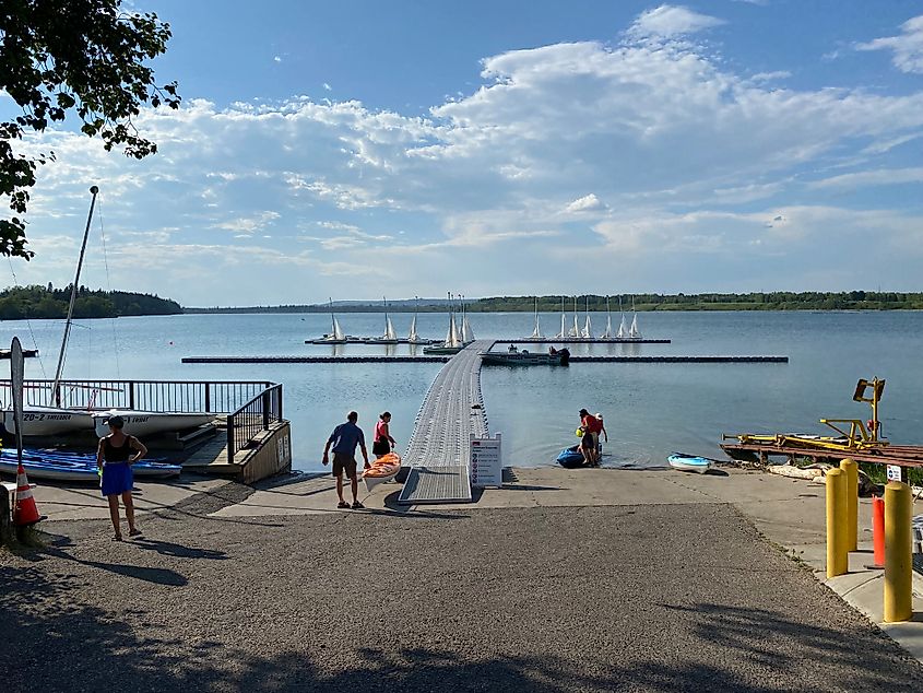 Kayakers launch into the Glenmore Reservoir, where anchored sailboats wait to greet them.