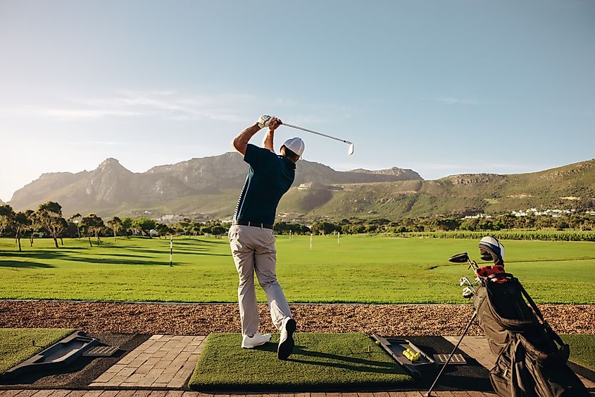 Male golfer taking a swing on a beautiful mountain course.