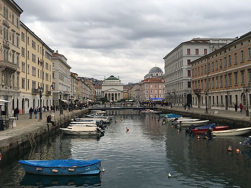 Small motor boats and stately buildings line a modest canal on a cloudy winter's day.