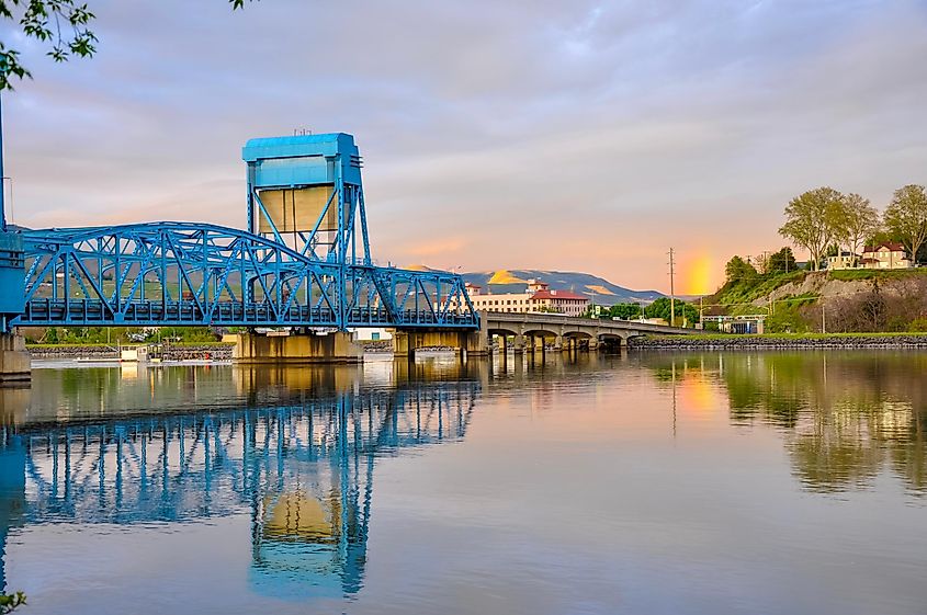 The historic Lewiston-Clarkston blue bridge reflects in the Snake River against the evening sky.