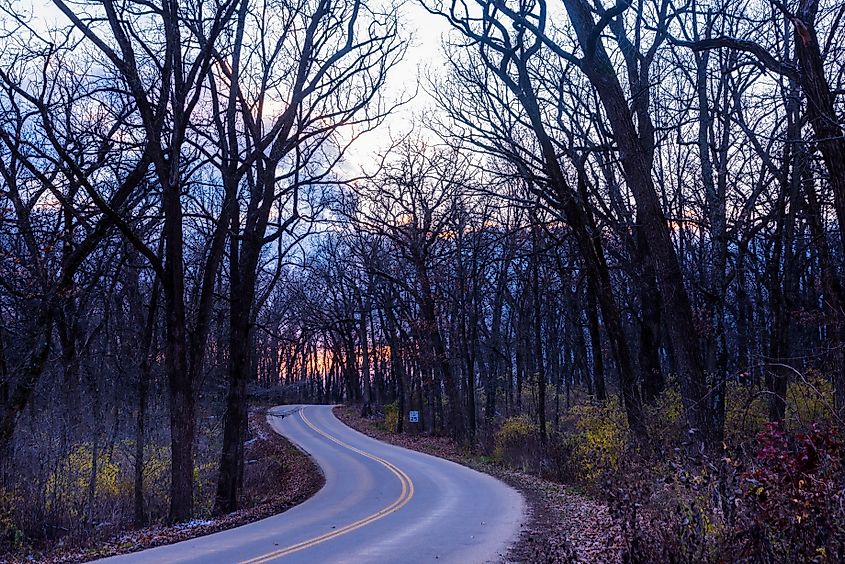 A serene sunset over a winding road through New Glarus Woods State Park in Wisconsin