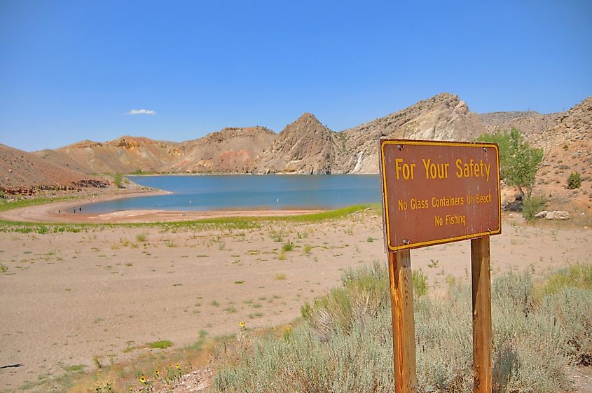 Sandy beach with safety sign and small hills at Boysen Reservoir in Wyoming