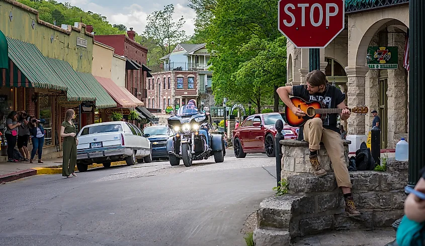 A musician playing a guitar on a street in Eureka Springs, Arkansas