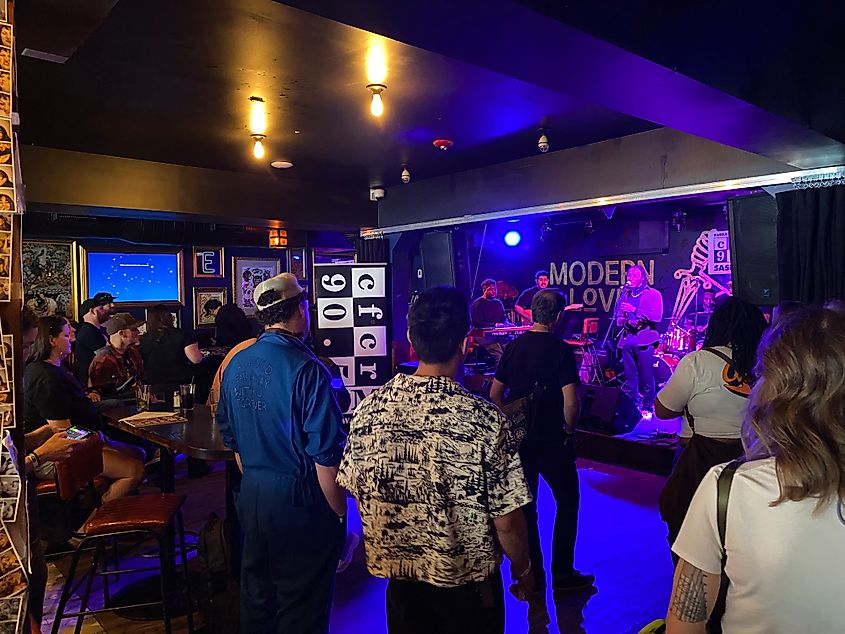 A small crowd watching a live band at a hip, indoor music venue known as Modern Love.  