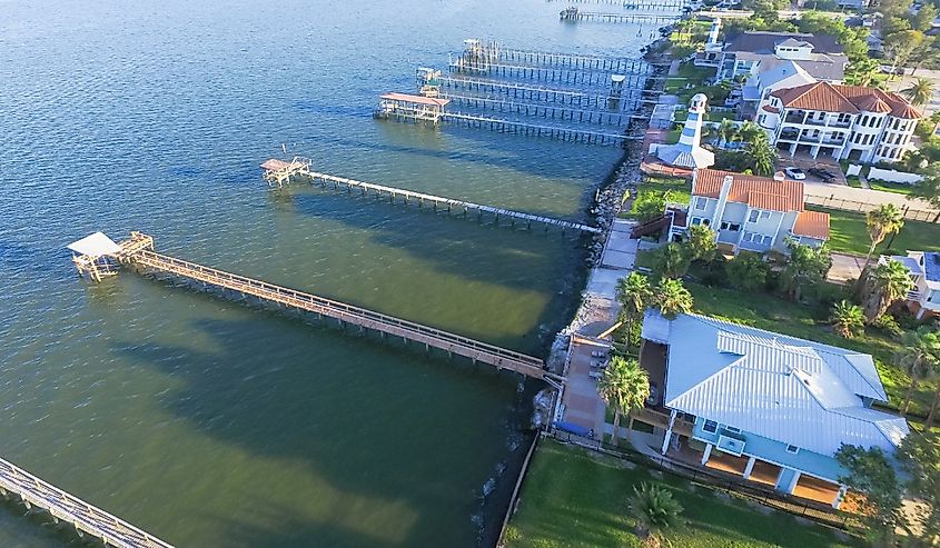 Aerial view three-story waterfront vacation home with fishing piers stretching out over the Galveston Bay in Kemah city, Texas,