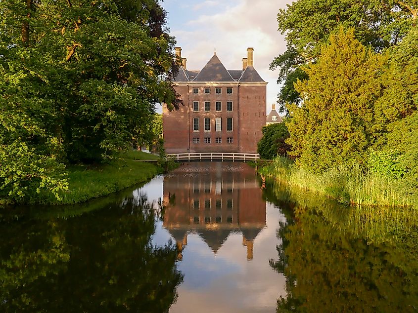 Castle Amerongen in the Netherlands, a historic Dutch manor surrounded by landscaped gardens, a moat, and tree-lined pathways