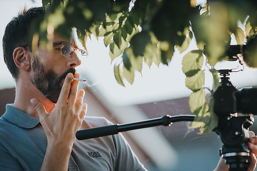 A shot of a videographer with a Sony camera smoking at a wedding in Sarajevo, Bosnia and Herzegovina. Editorial credit: Wirestock Creators / Shutterstock.com