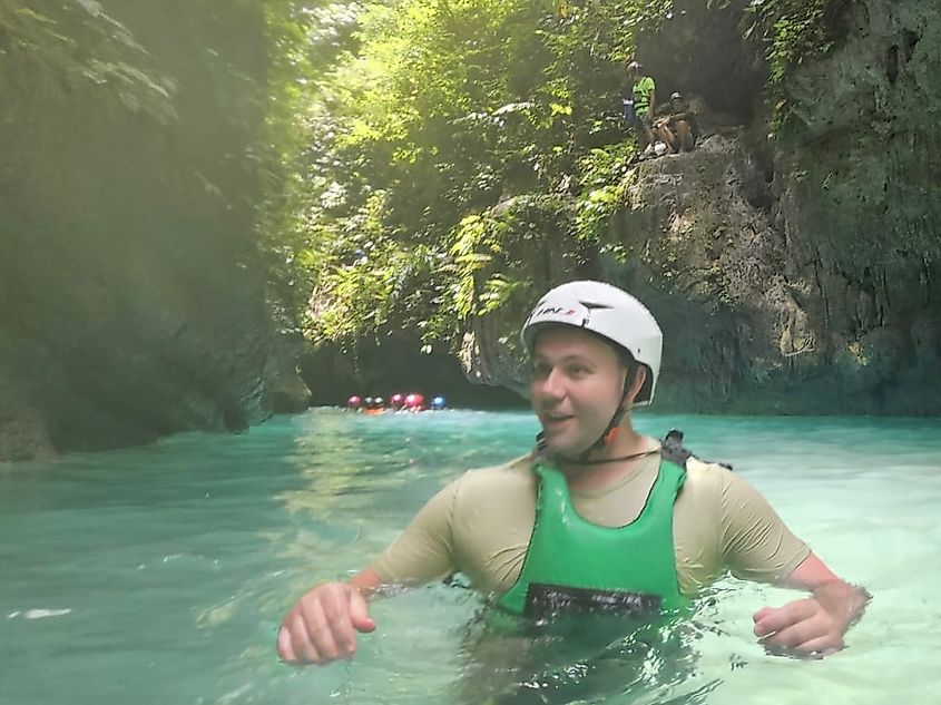 A man in a life jacket and helmet explores the watery canyons of the Philippines on a canyoning tour.