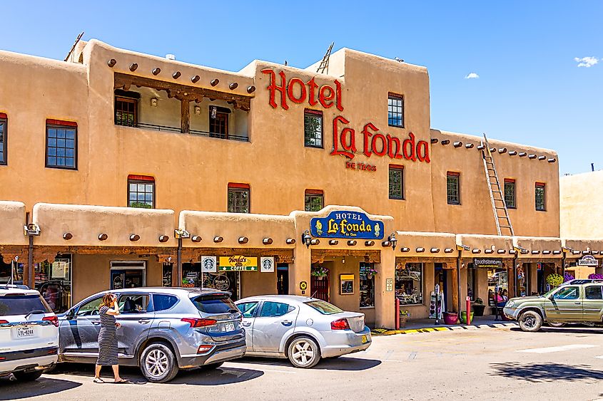 Downtown McCarthy's Plaza Square in Taos, New Mexico, featuring the Hotel La Fonda with its red text sign on the exterior, in the historic village area.