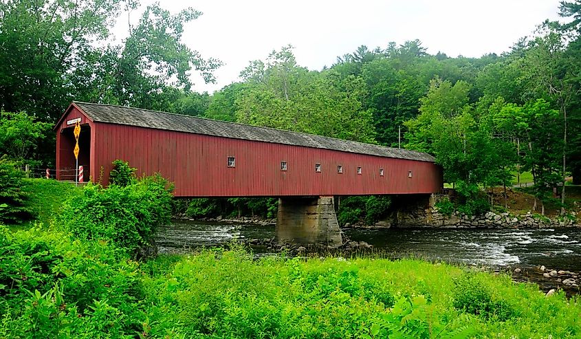 The cornwall connecticut covered bridge over the houstanic river in West Cornwall / sharon on an overcast day.