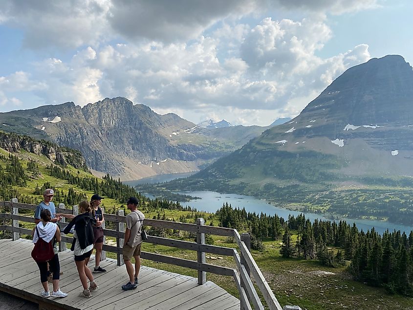 An adventurous family enjoying the view of Glacier National Park's Hidden Lake and its surrounding mountains.