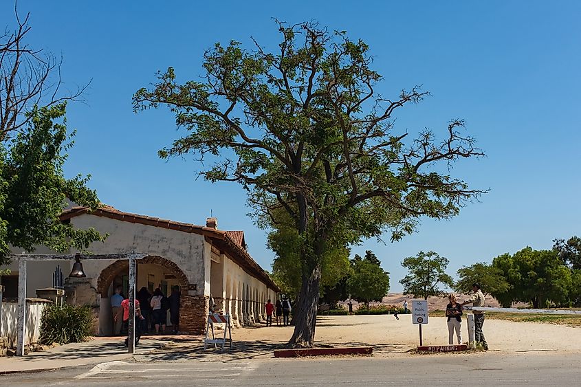 The entrance bell with tourists visiting the mission at the San Juan Bautista State Historic Park.