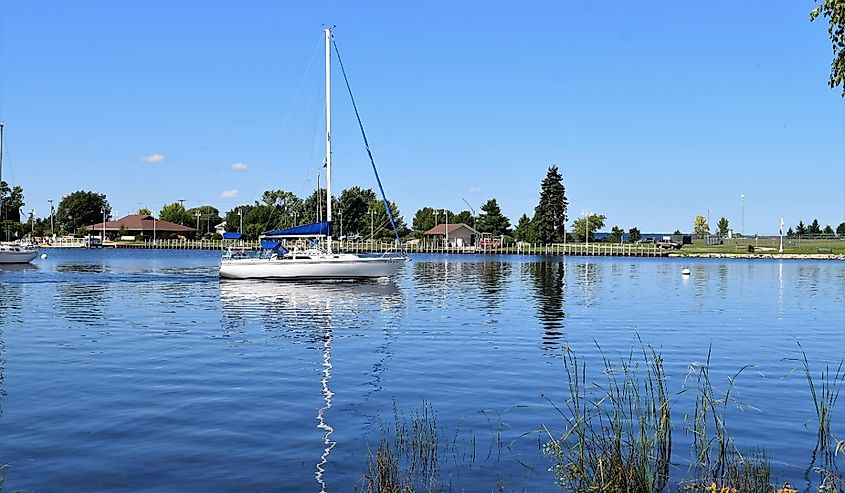 Sail boat in marina with mast reflection in Escanaba, Michigan.