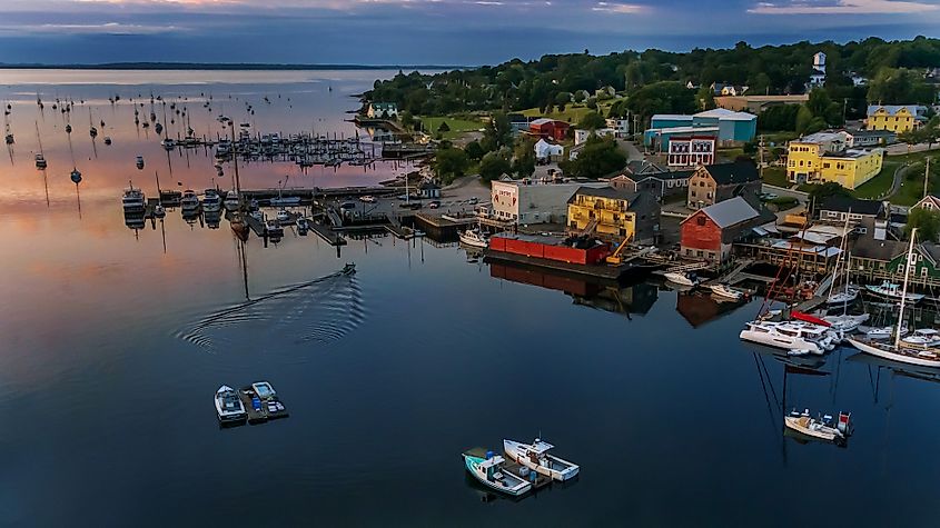 Overlooking an early morning in Belfast, Maine with boats on the water and homes along the waterfront.