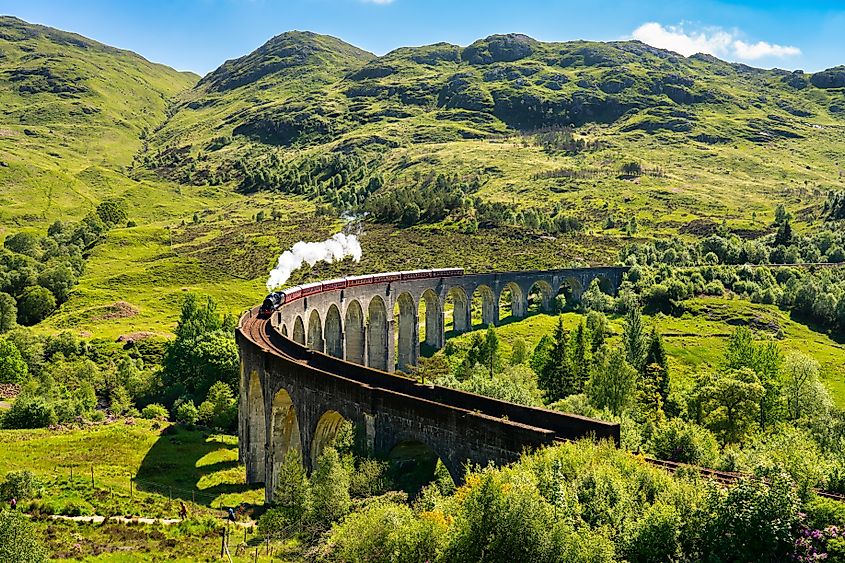 Glenfinnan Railway Viaduct in Scotland with the steam train passing over.