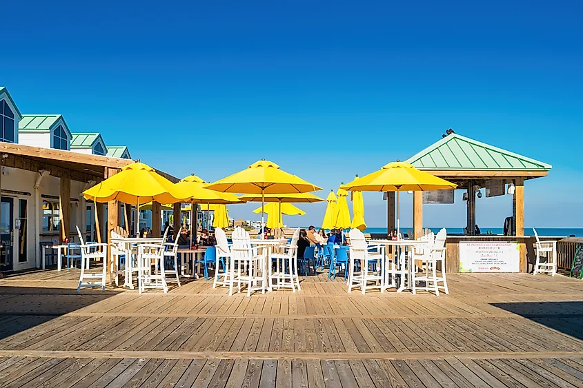 People enjoy the patio of a bar-restaurant on the Folly Beach Pier