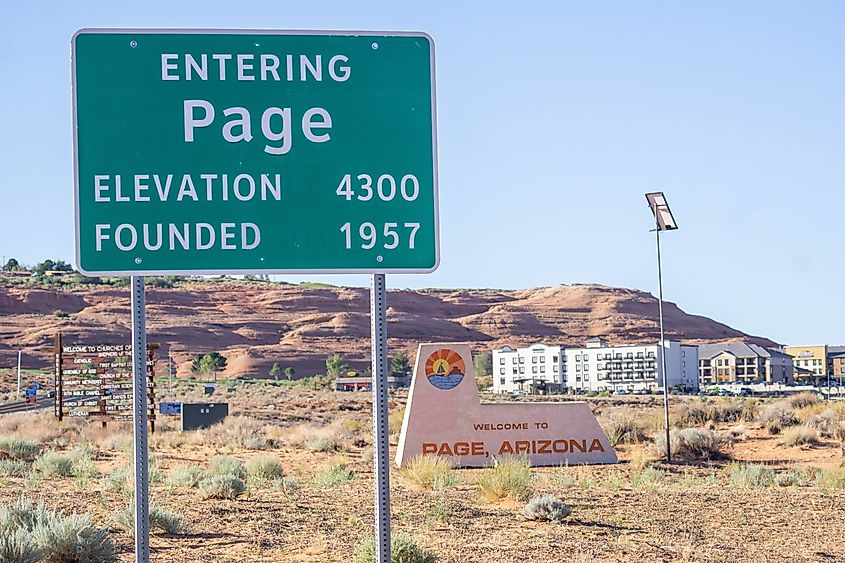 The green city limits sign marking the entrance to Page, Arizona, set against the desert landscape.