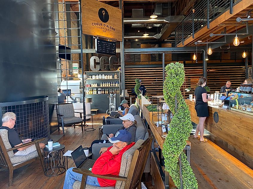 People sitting around the fireplace in a large coffee shop.