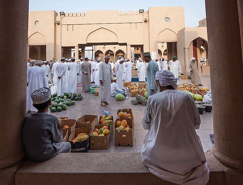 Men gathered at Nizwa Market, Oman. Image Credit Khalil Alobaidani via Shutterstock.