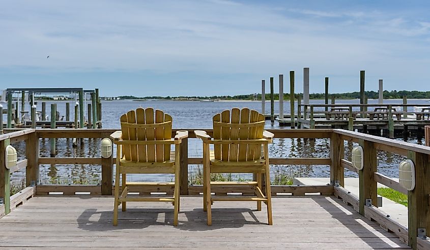 Two wooden chairs on a dock in Swansboro, North Carolina