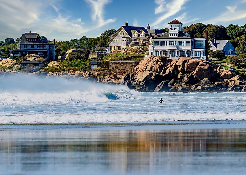 Good Harbor Beach in Gloucester, Massachusetts, a scenic and popular destination with a large white cottage known as Sherman Cottage, built in the 1880s, overlooking the shoreline.