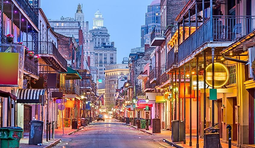 Bourbon St, New Orleans, Louisiana, USA cityscape of bars and restaurants at twilight.